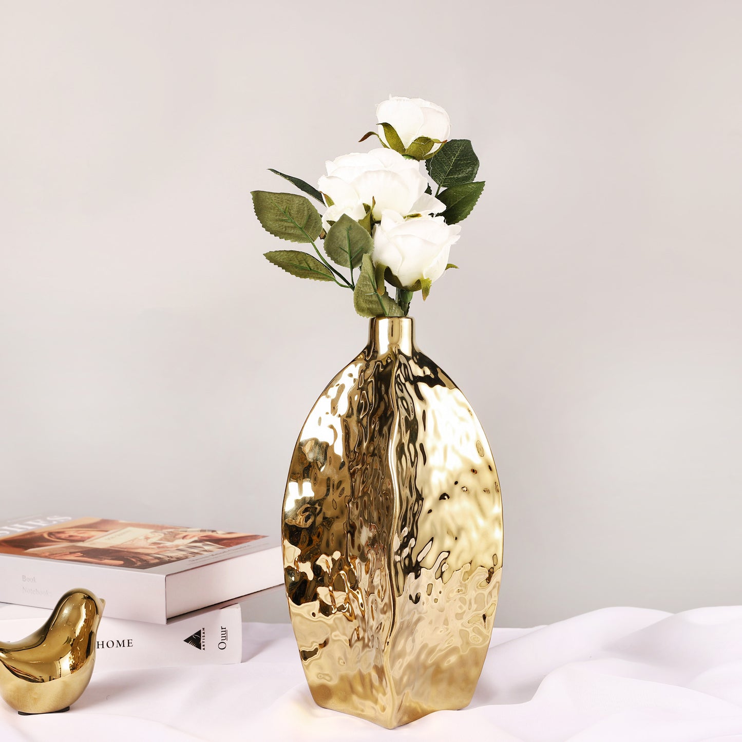 Hammered gold ceramic vase – irregular sculptural shape
Set of three hammered gold vases in S/M/L on table
Modern glam gold ceramic vase with white flowers – DECASA by VS