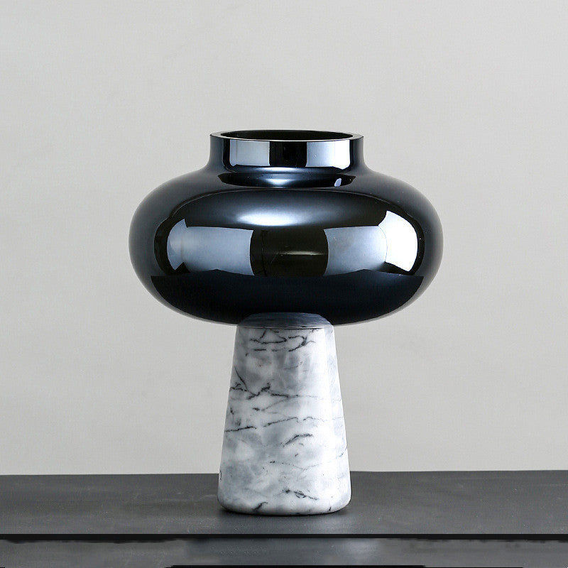 Black ceramic vase with marble base on a gray surface