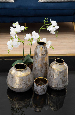 Decorative vases with white flowers on a reflective surface