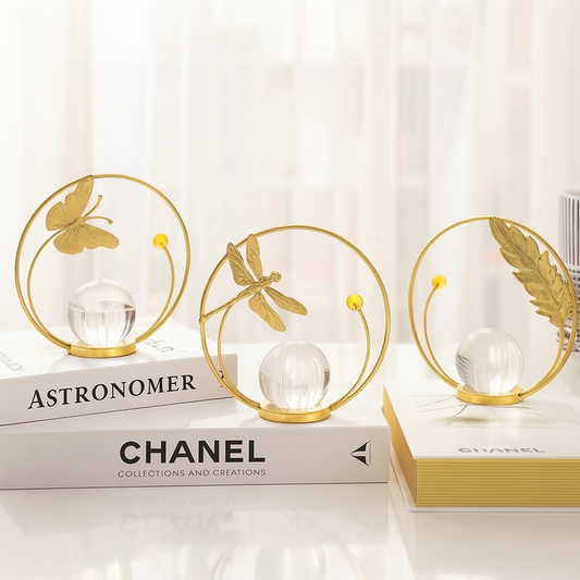 Decorative items with gold butterfly, dragonfly, and leaf designs on Chanel books.