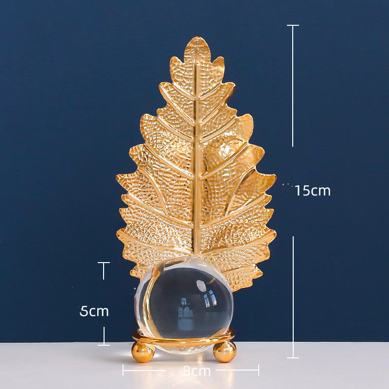 Gold leaf decorative item with measurements on a blue background