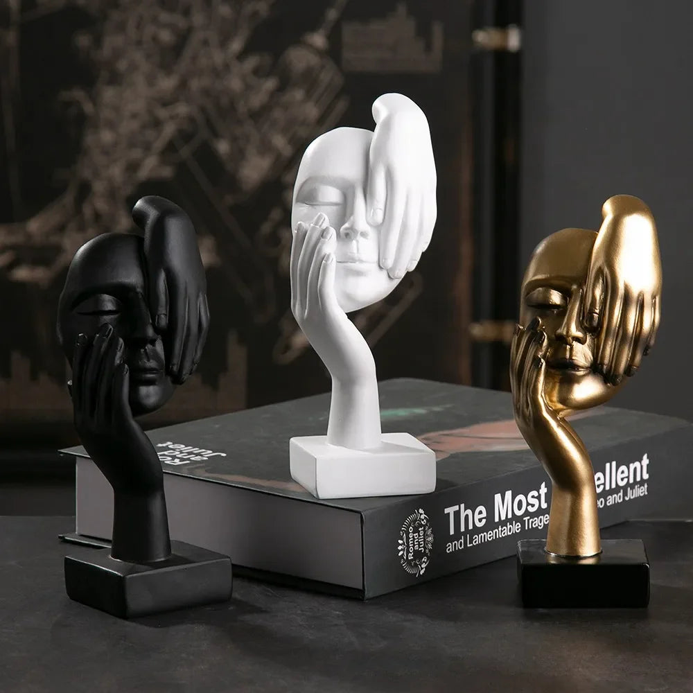 Three artistic hand sculptures in black, white, and gold on a dark surface with 'The Most Excellent' text.