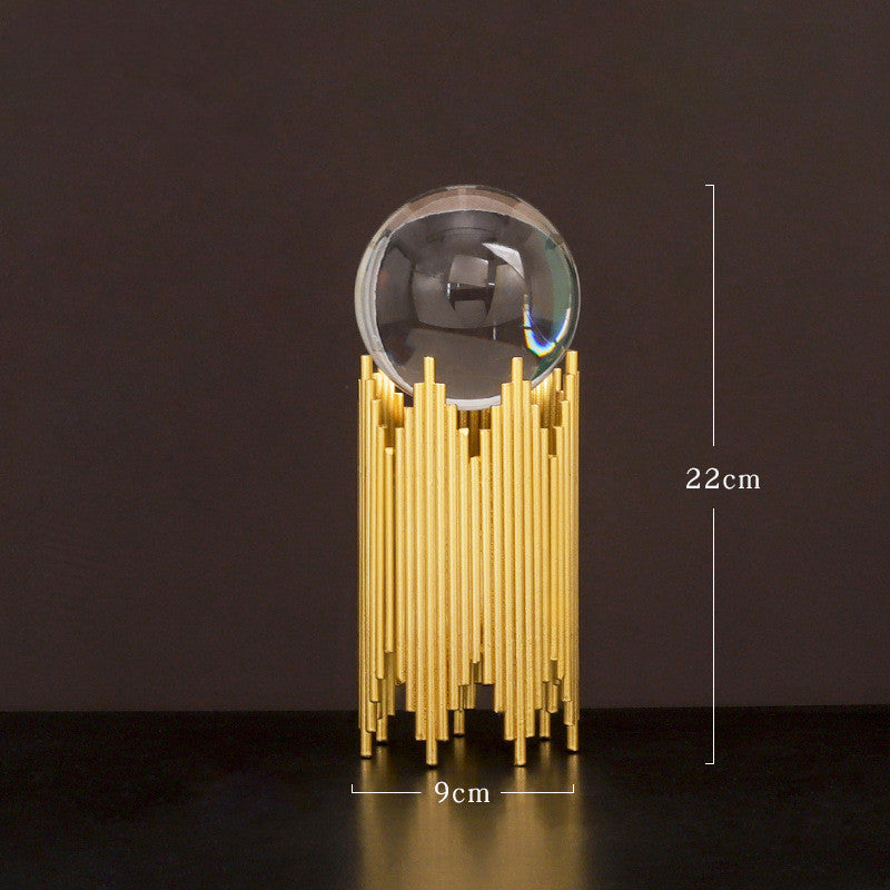 Decorative object with gold base and clear sphere on a dark background