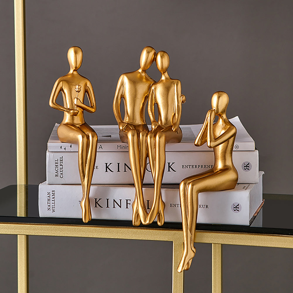 Gold figurines on books against a gray background