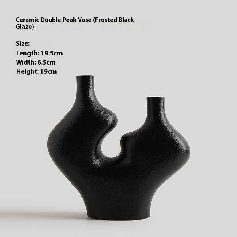 Ceramic double peak vase with frosted black glaze on a light gray background