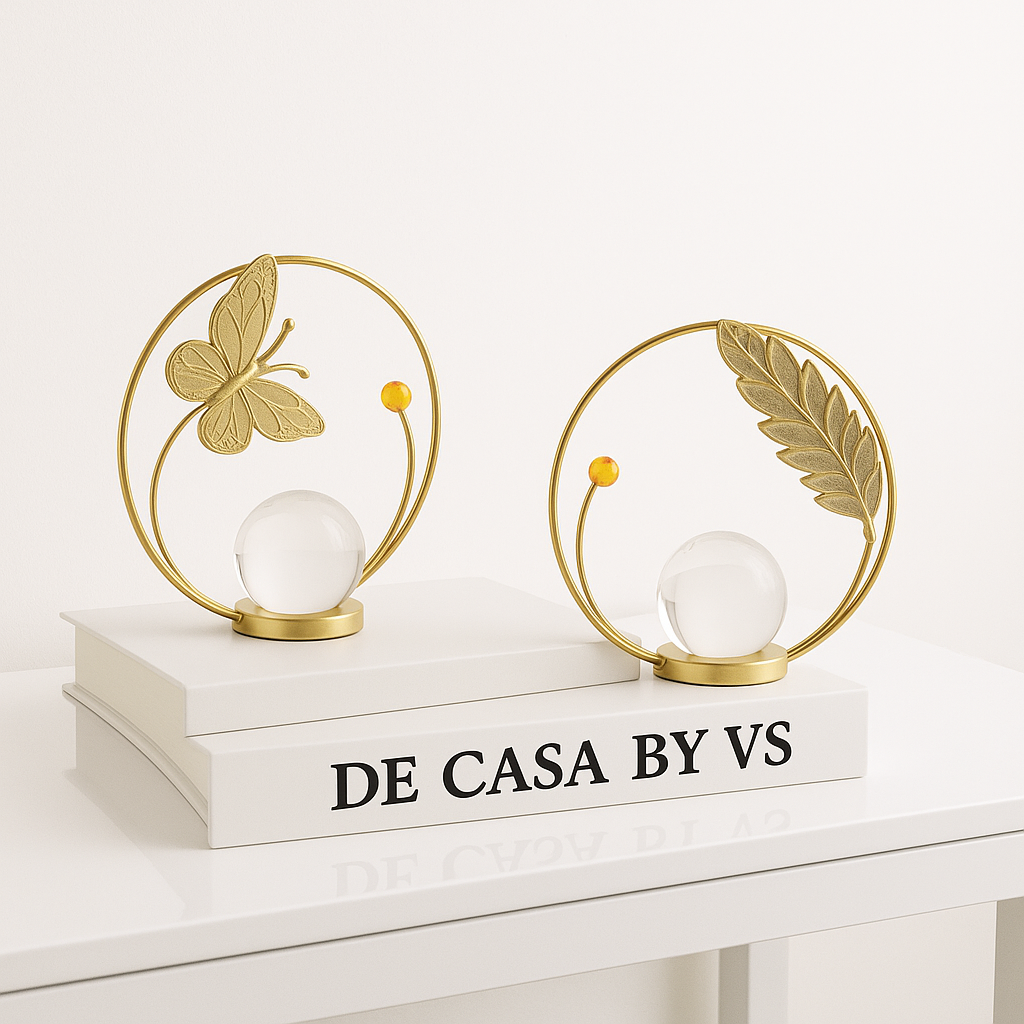 Decorative table lamps with butterfly and leaf designs on a white surface, featuring 'DE CASA BY VS' branding.
