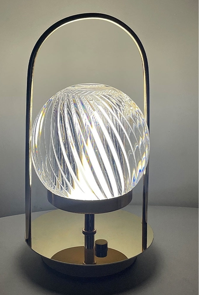 Modern table lamp with a glass globe and metal frame on a neutral background