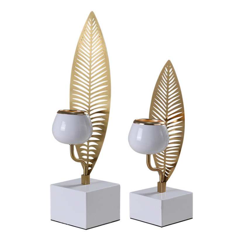 Two decorative candle holders with leaf designs on a white background