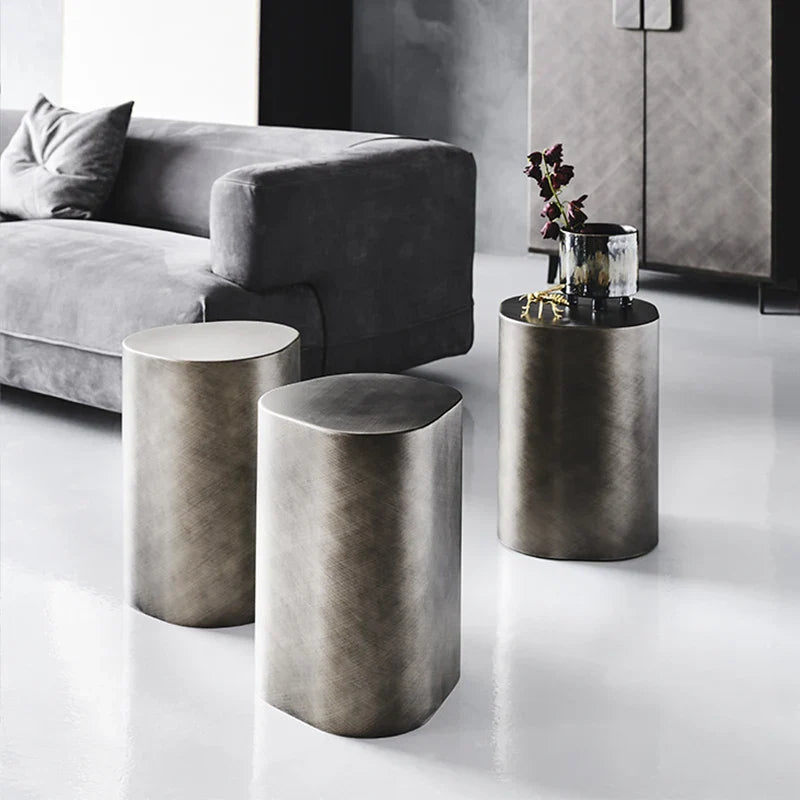 Three metallic side tables in a modern living room setting.