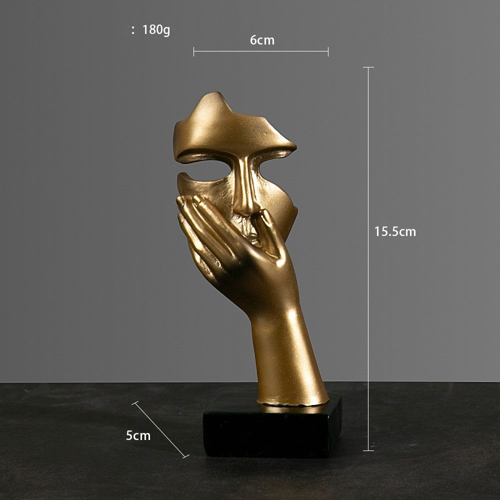 Gold mask sculpture on a black base with measurements indicated